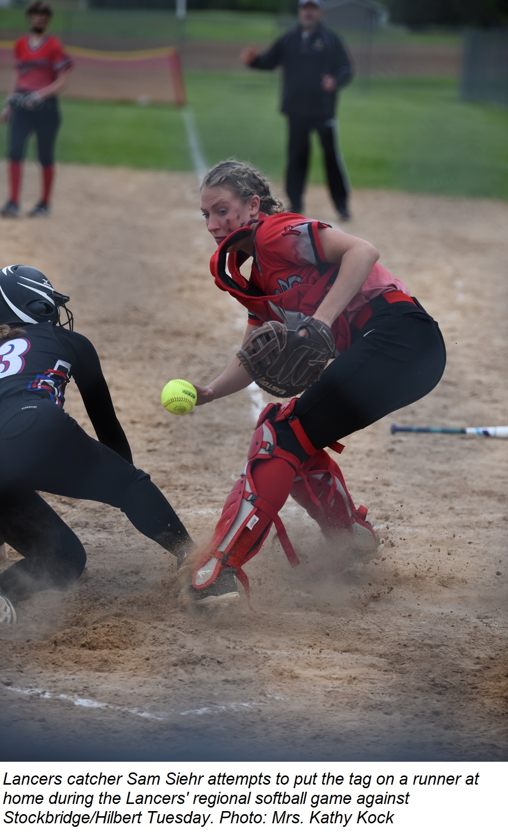 Catcher Sam Siehr attempts to make an out at home plate during the Lancers' regional softball game at Stockbridge Tuesday.